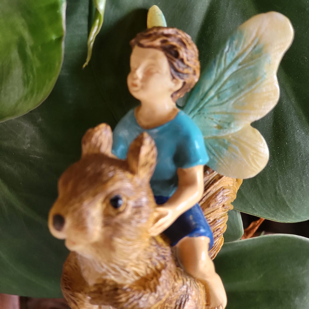 Fairy Boy Riding a Squirrel displayed in a garden