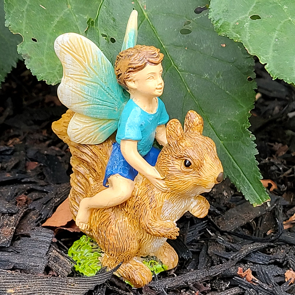 Fairy Boy Riding a Squirrel displayed in a garden