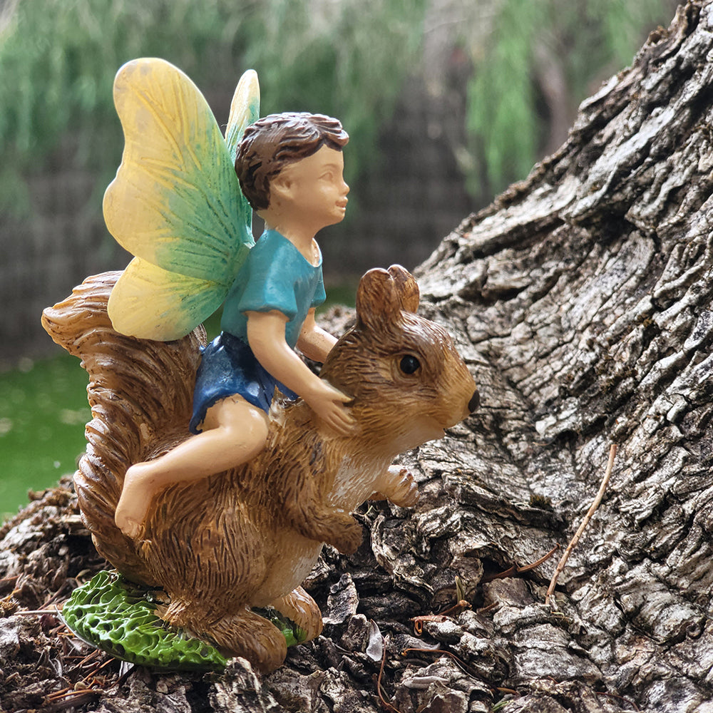 Fairy Boy Riding a Squirrel displayed in a fairy garden setting