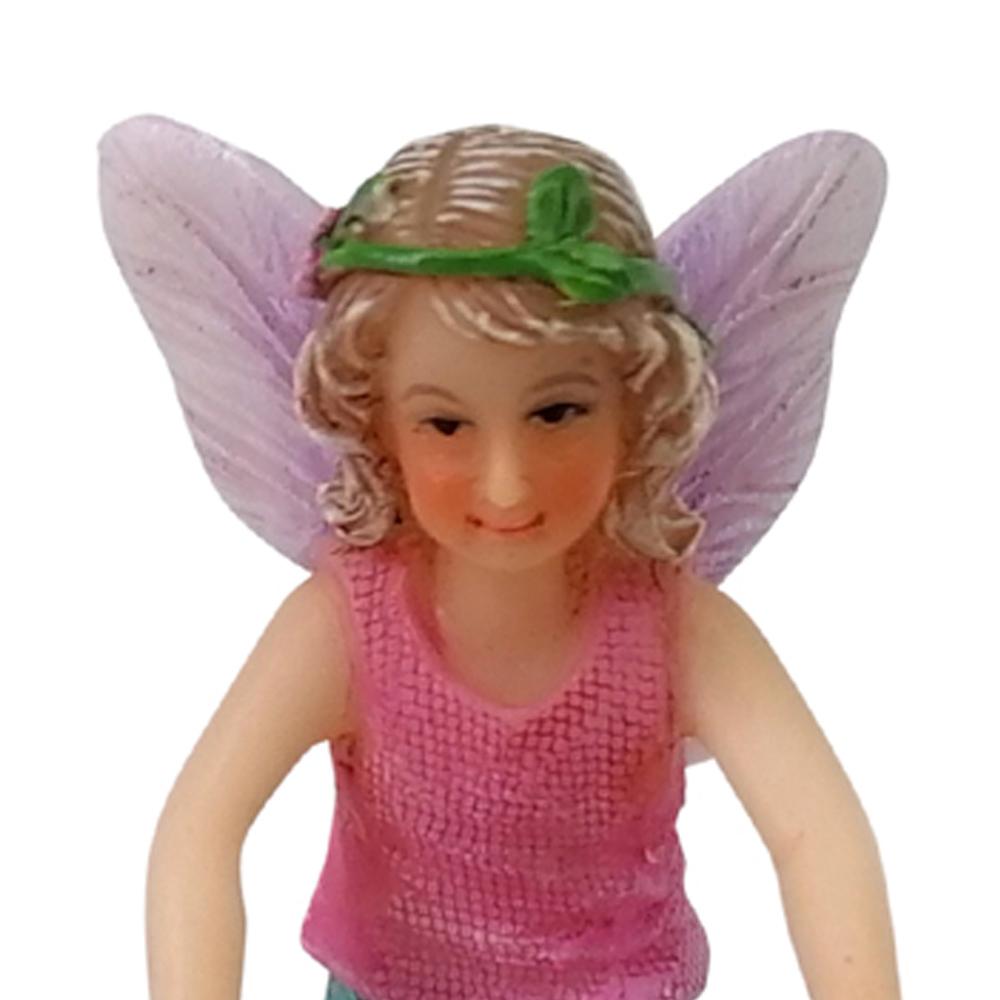Close Up view of Fairy Sophia with Puppy, a miniature fairy figurine, showing face detail and floral crown in blonde hair.  