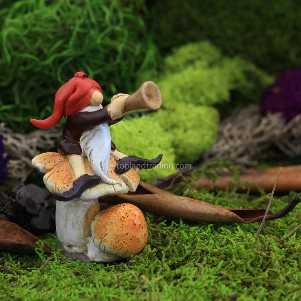 Miniature Garden Gnome Playing Horn on a Mushroom displayed on a white background