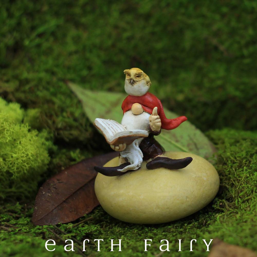 polyresin miniature gnome figurine, posed sitting on a rock with a book and an owl sitting upon his head
