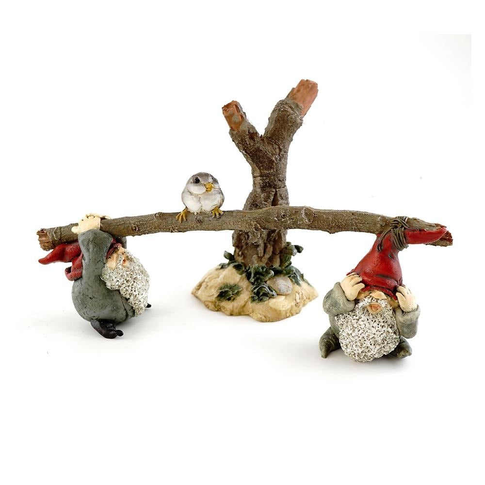 Miniature polyresin gnome figurines, depicting two gnomes playing on a seesaw, with a little bird on top of the seesaw's tree base