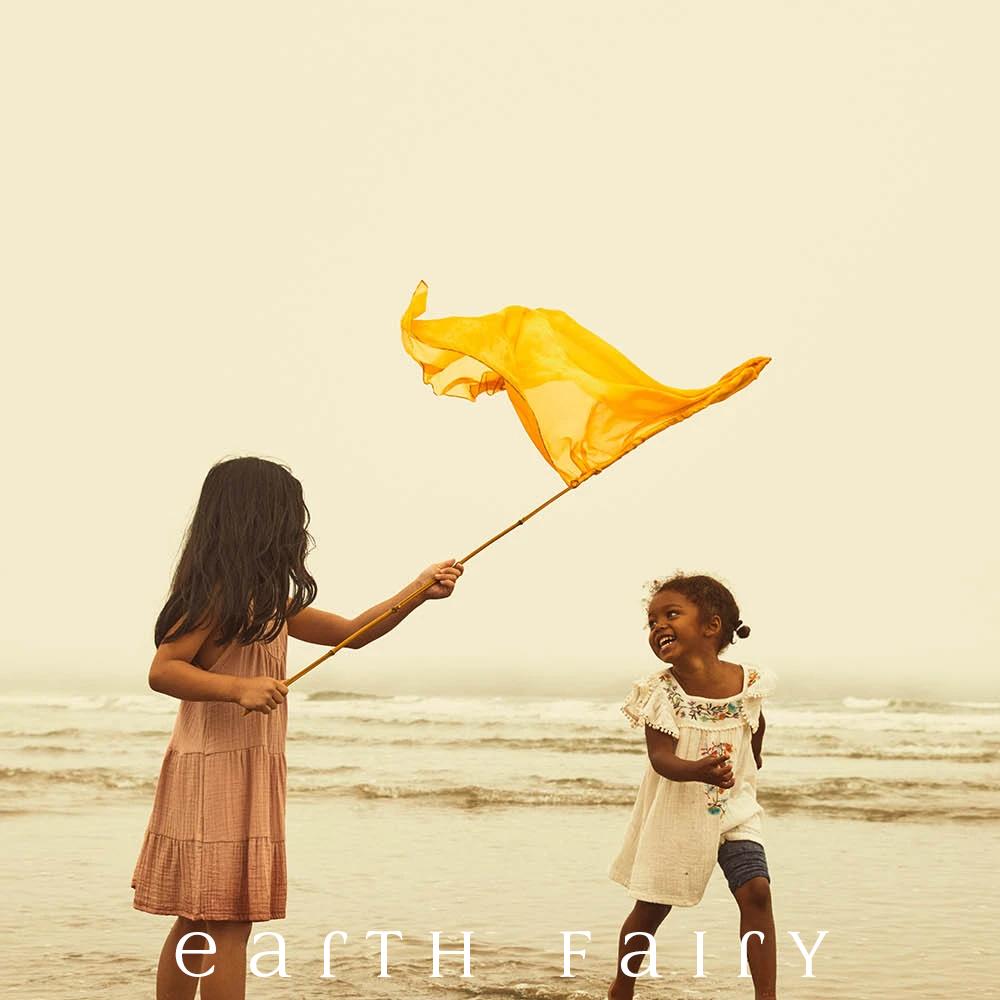 Mini Playsilk, 54cm Square in Gold, showing children making a flag with pole and playing on beach, from The Earth Fairy Silk Collection