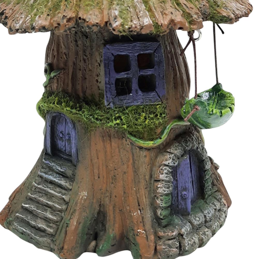 Close up view of Moss Tree House with Hammock - Solar, a miniature fairy house for the garden with mossy wooden roof and purple arched door, and a small hammock hanging to the side