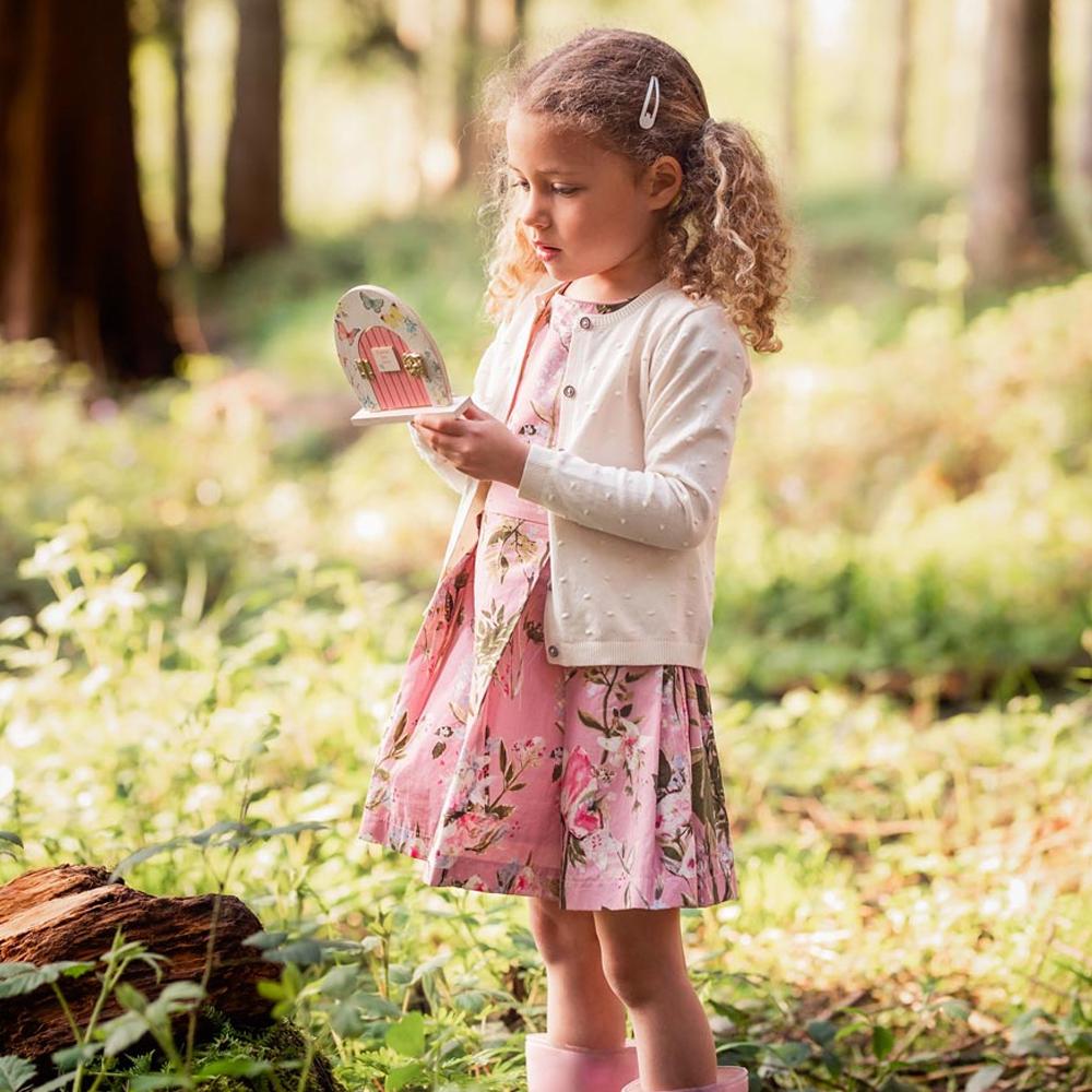 Truly Fairy Wooden Fairy Door, Fairy Themed Party Decoration, displayed being held by a little girl in the forest