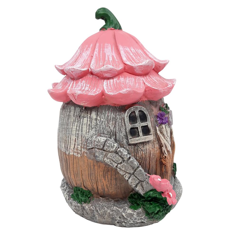 Side view of the Welcome Fairy Flower House, a miniature fairy house for the garden, with tree trunk style base and pink flower roof and winding staircase to the side displayed on a blank background