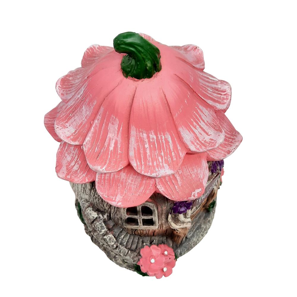 Overhead view of the Welcome Fairy Flower House, a miniature fairy house for the garden, with tree trunk style base and pink flower roof and winding staircase to the side displayed on a blank background