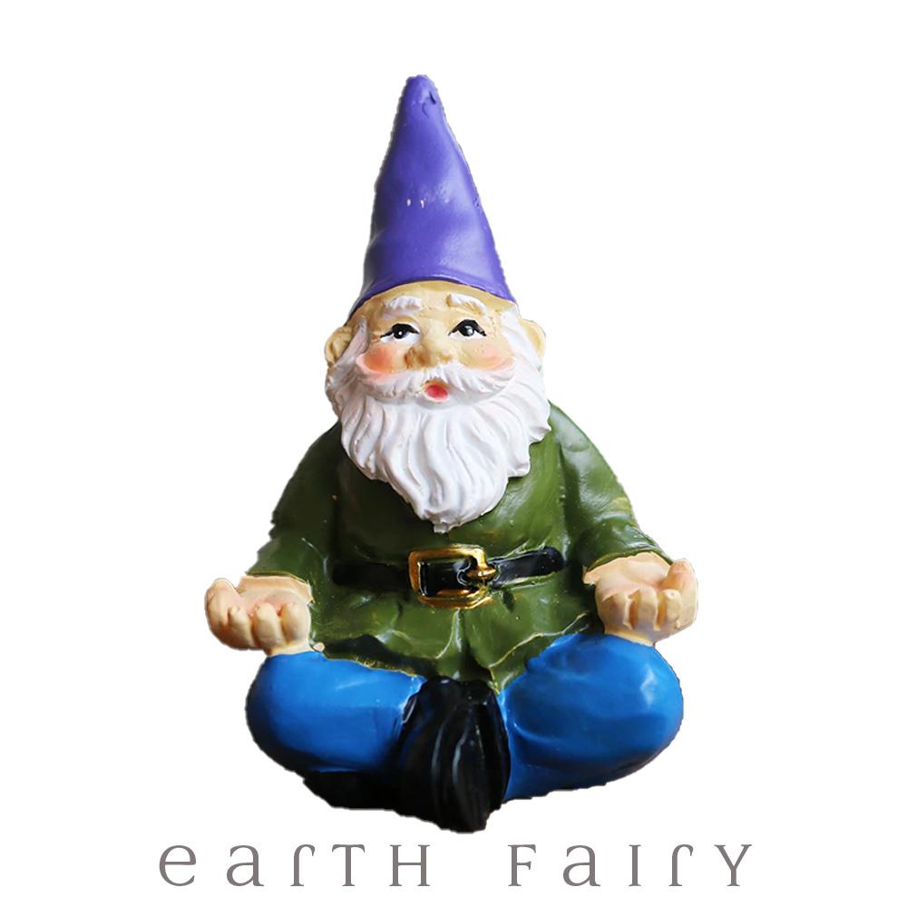 Yoga Gnome, wears blue pants and green belted coat with a purple hat and sits in a classic yoga pose